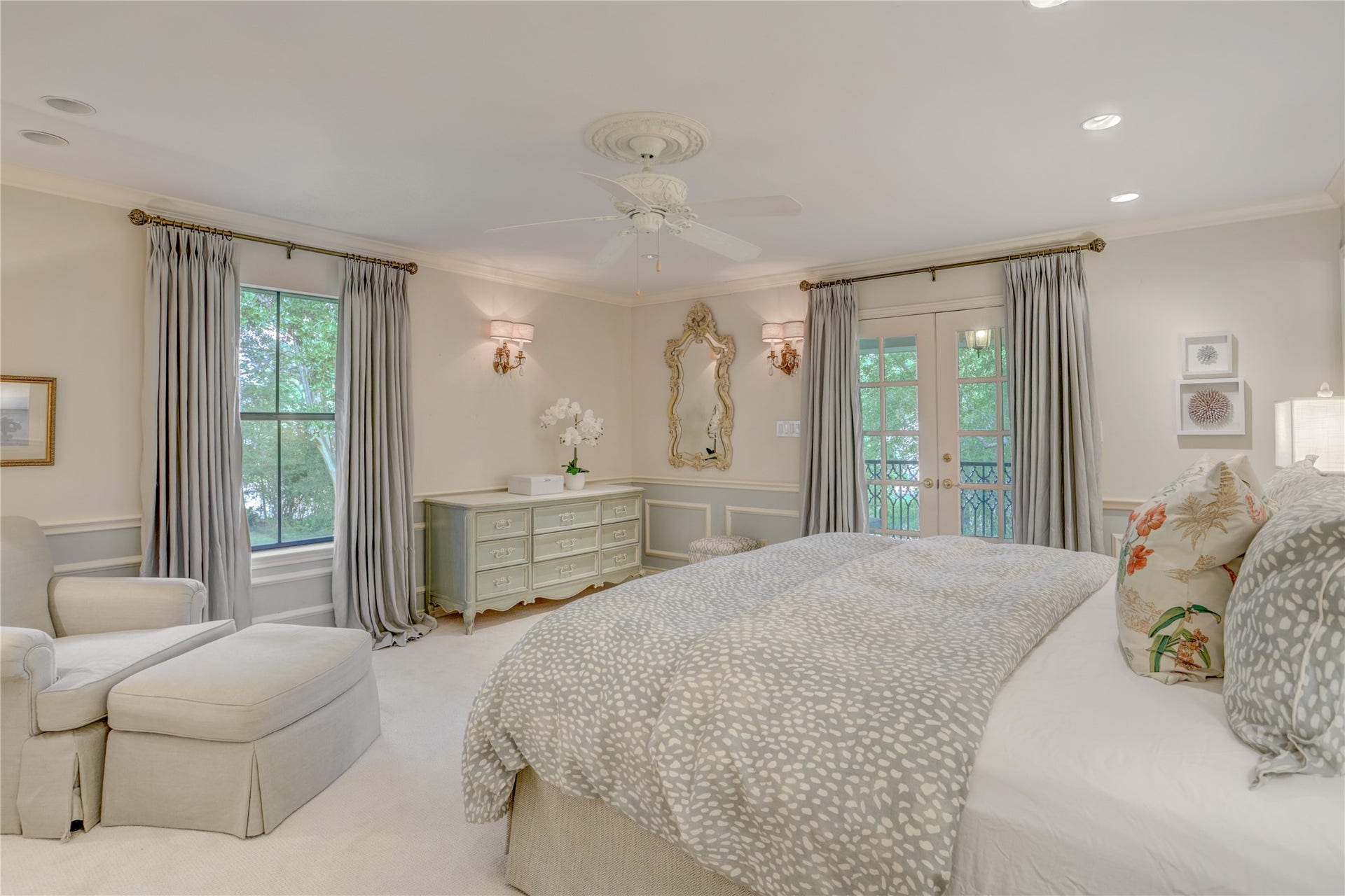 This large secondary bedroom has a walk in closet and French doors onto the front balcony
