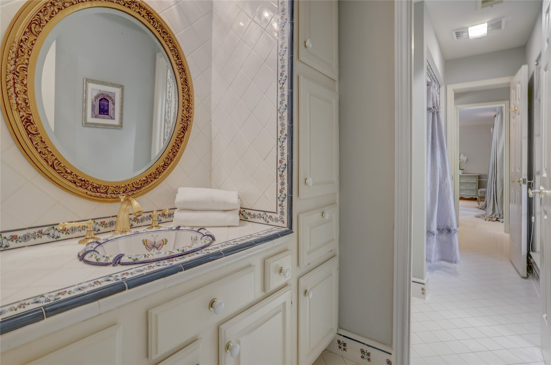 This charming Hollywood bath with delightful tile and sinks is between the two front bedrooms