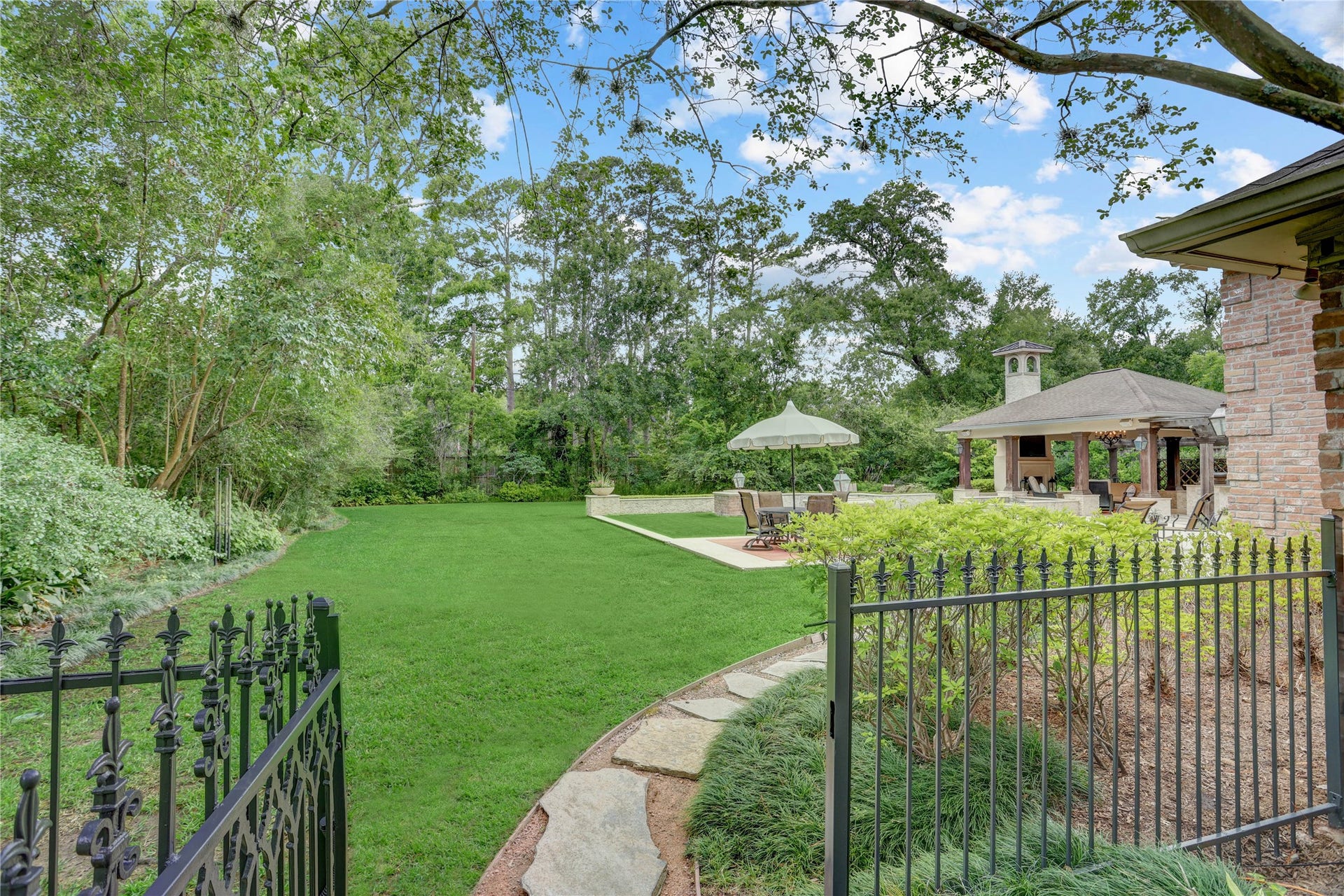 The charming gate at the  end of the front walkway leading to the patios and spectacular yard