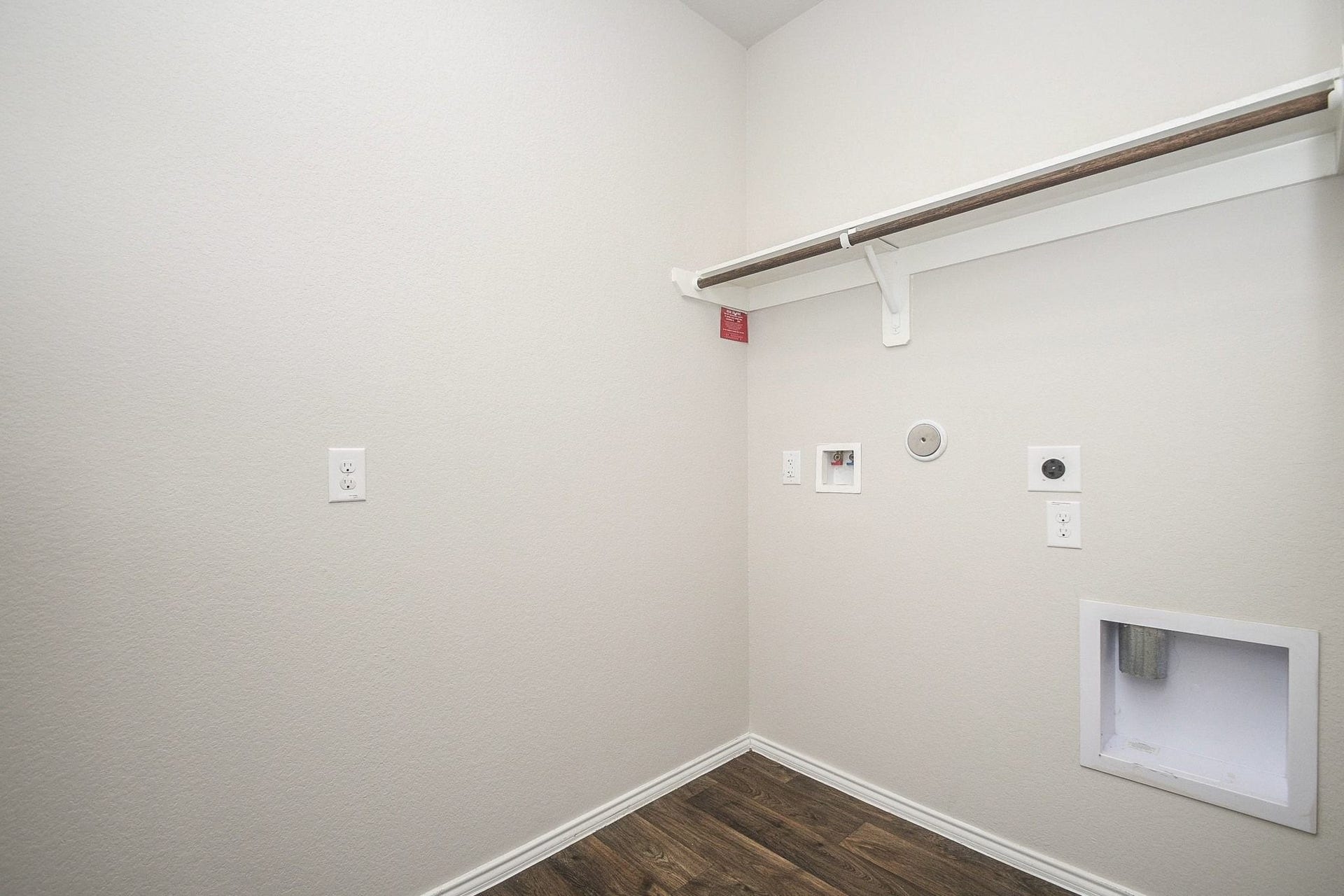 Spacious laundry room with hookups, shelving, and elegant flooring for a functional and organized space.