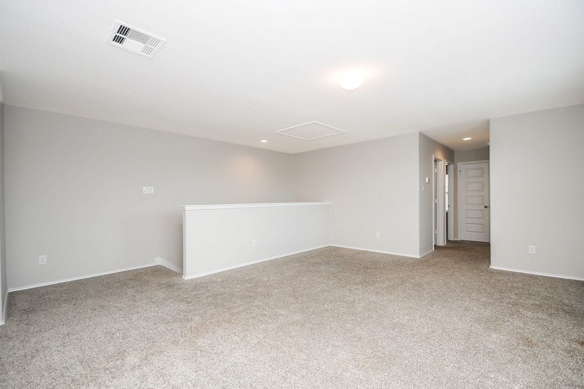 Spacious and bright, Gameroom upstairs featuring plush carpeting and neutral tones, perfect for a versatile living area or additional bedroom.