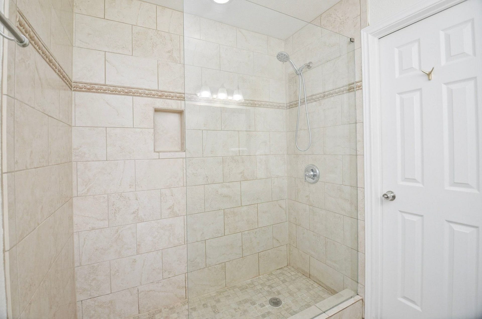 5515 Saxon Drive, Houston, TX 77092 Walk-in shower that boasts neutral earth tones, with half glass door and built-in niche for bath essentials!