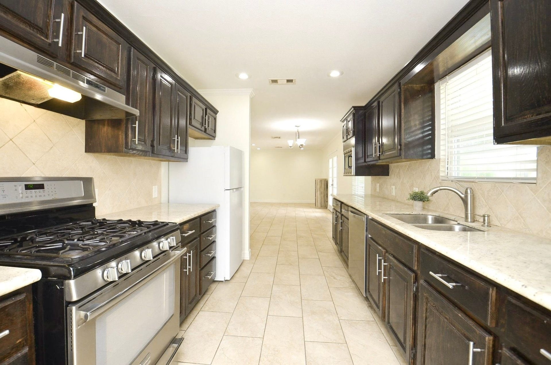 5515 Saxon Drive, Houston, TX 77092 Bring out your inner chef in this well-equipped kitchen with ample counter space, rich wood cabinetry, and stainless steel appliances.