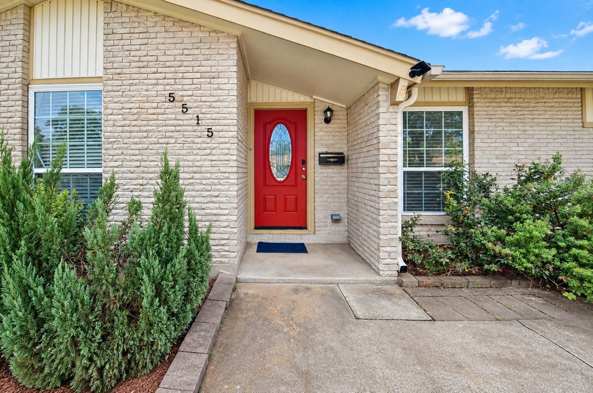 5515 Saxon Drive, Houston, TX 77092 Welcoming mid-century entryway with a bold red front door & light brick exterior.