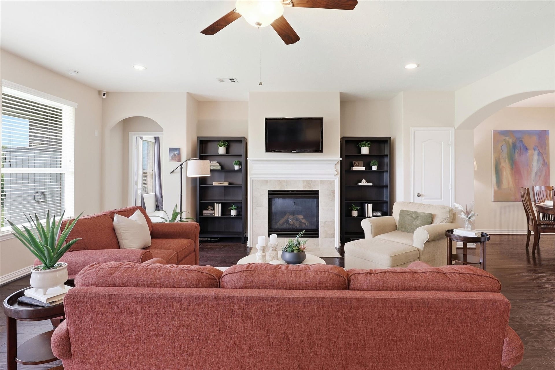 3219 Cotton Ranch Drive, Katy, TX 77494 A beautiful gas fireplace with an elegant mantel and tile surround serves as the room's focal point, while recessed niches on either side provide ideal spaces for freestanding bookcases, artwork, or curated decorative accents.