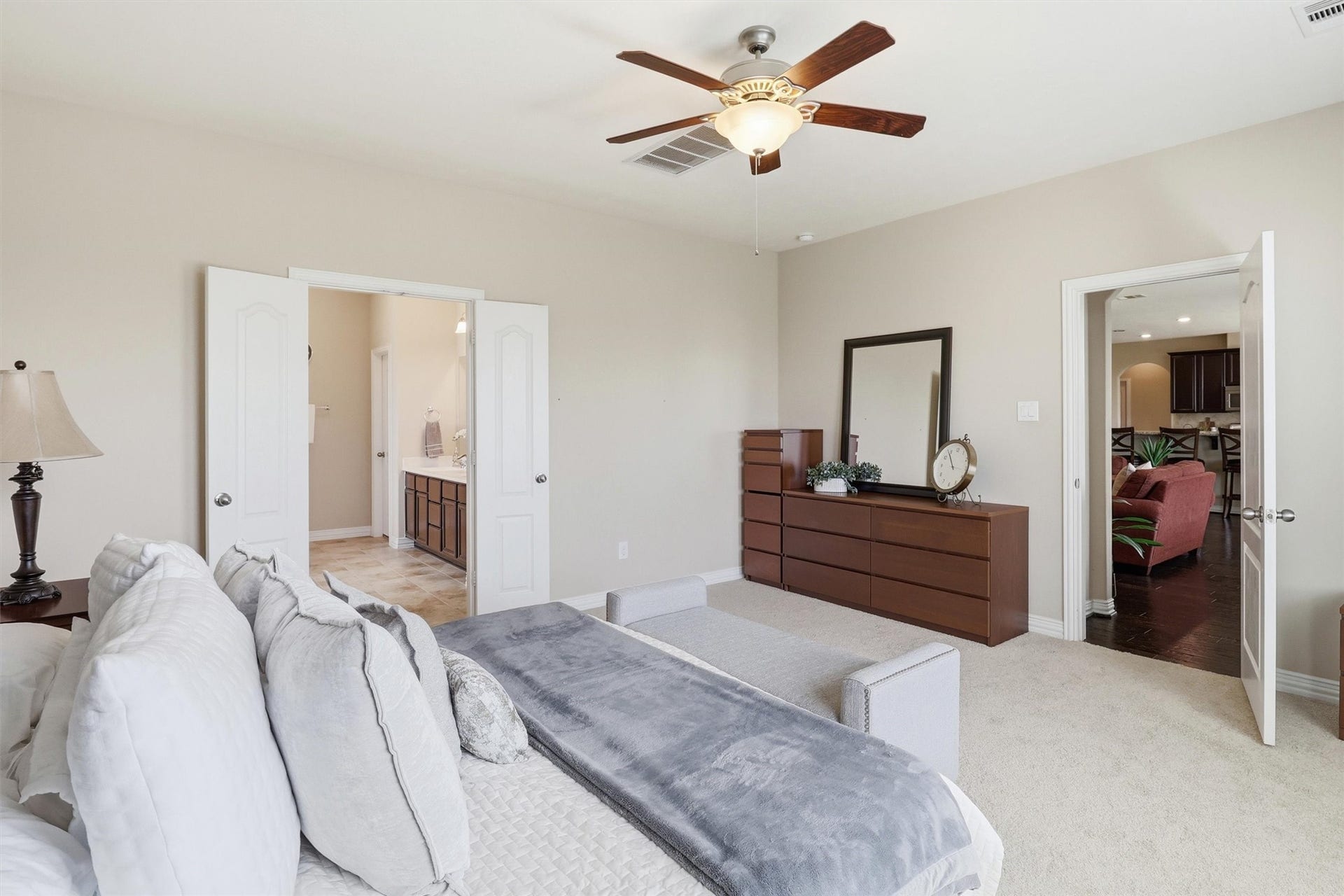 3219 Cotton Ranch Drive, Katy, TX 77494 Spacious and inviting, this private retreat offers room for oversized furnishings as well as a cozy sitting area or reading nook. Double doors lead to the spa-inspired ensuite bathroom, enhancing the suite's sense of comfort and privacy.