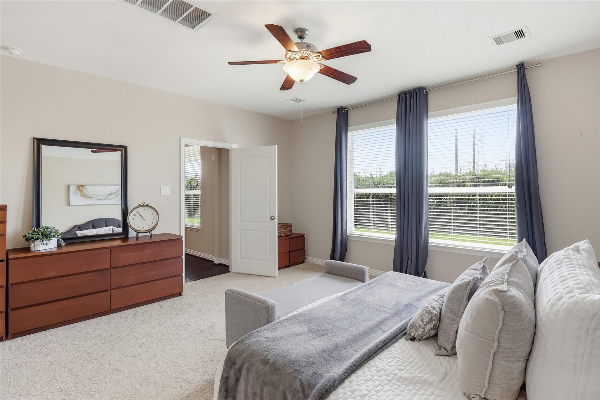 3219 Cotton Ranch Drive, Katy, TX 77494 Soft neutral tones, plush carpeting, a ceiling fan, and expansive windows fill the room with abundant natural light, creating a bright yet tranquil atmosphere.