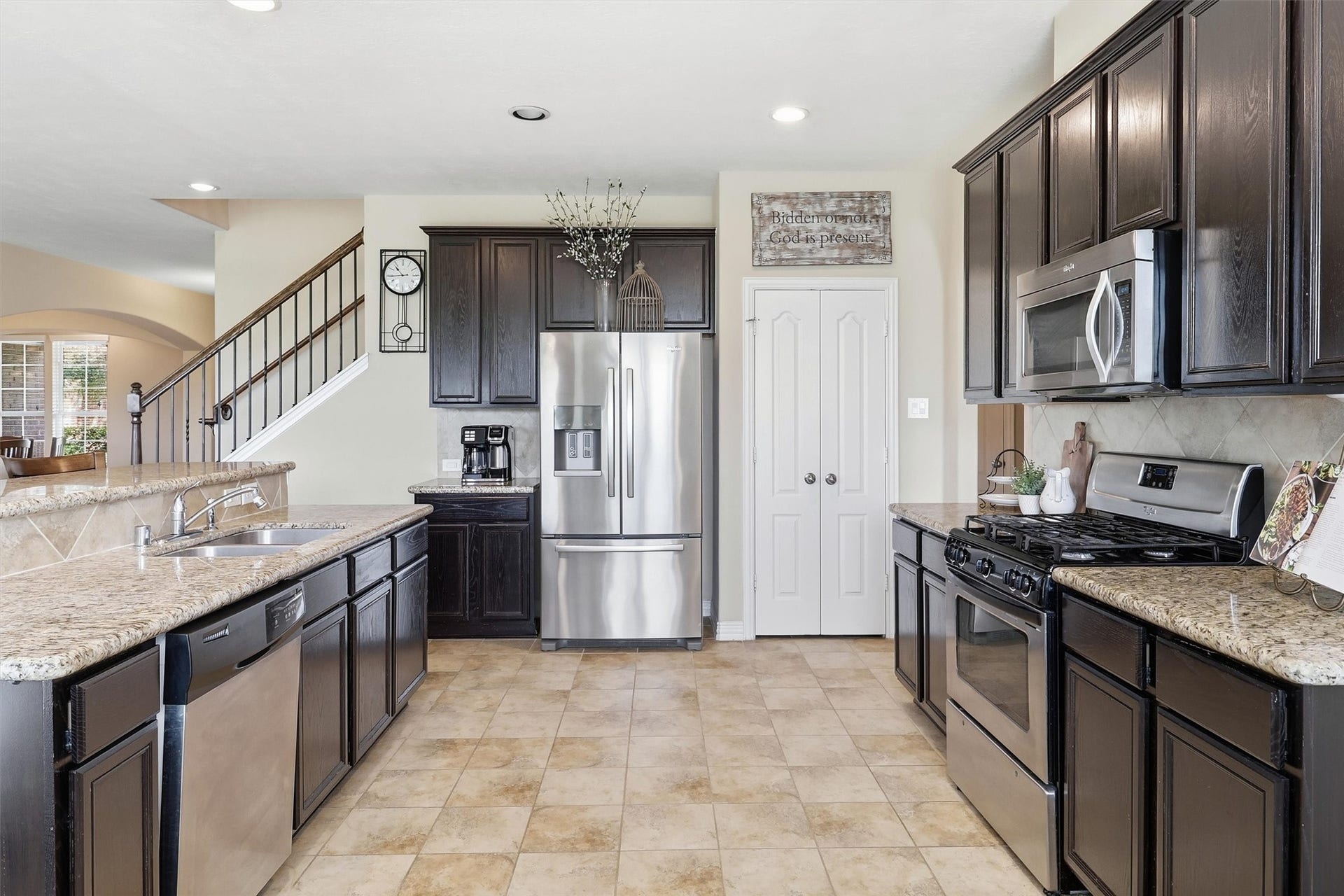 3219 Cotton Ranch Drive, Katy, TX 77494 Rich wood 42" cabinetry pairs beautifully with gleaming granite countertops, a classic tile backsplash, and stainless steel appliances, creating a warm yet sophisticated space for cooking and gathering.