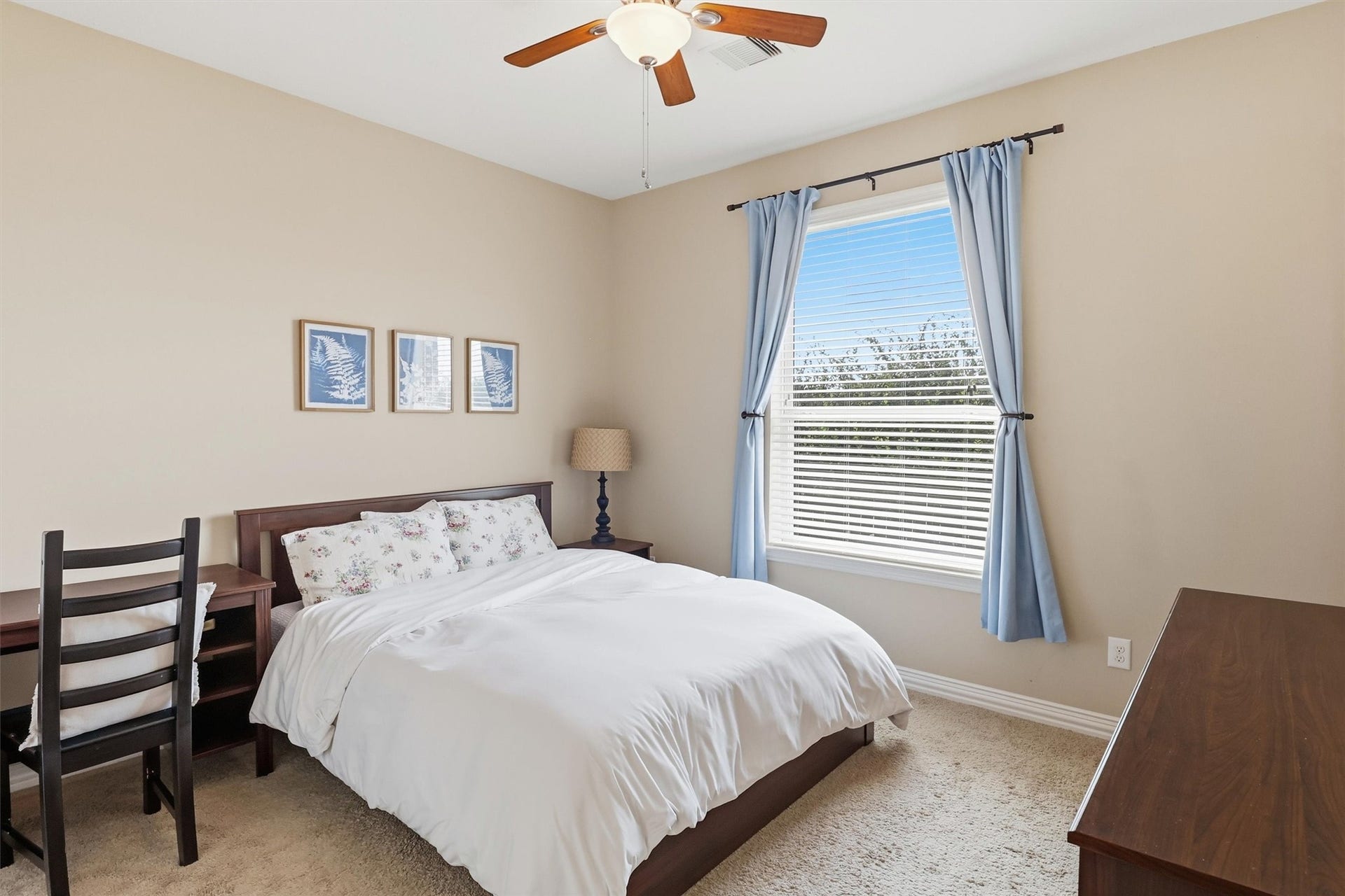 3219 Cotton Ranch Drive, Katy, TX 77494 This spacious first-floor secondary bedroom offers plush carpeting, abundant natural light, a ceiling fan, and a generous closet, creating a comfortable retreat for family or overnight guests. A nearby full bathroom adds everyday convenience.