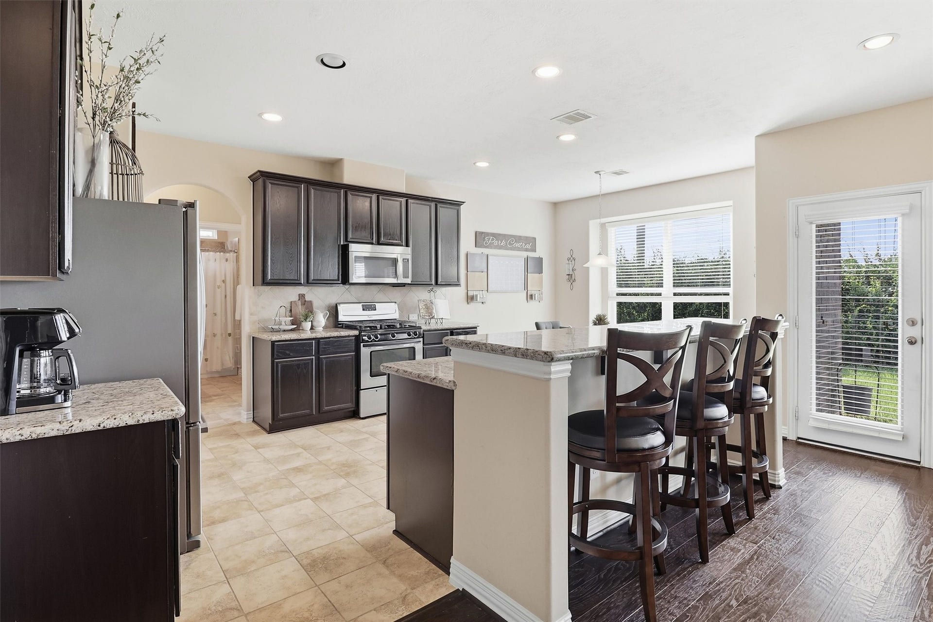 3219 Cotton Ranch Drive, Katy, TX 77494 The beautifully appointed island kitchen is designed to impress, featuring rich cabinetry, granite countertops, stainless steel appliances, and an oversized breakfast bar with seating for family and guests.
