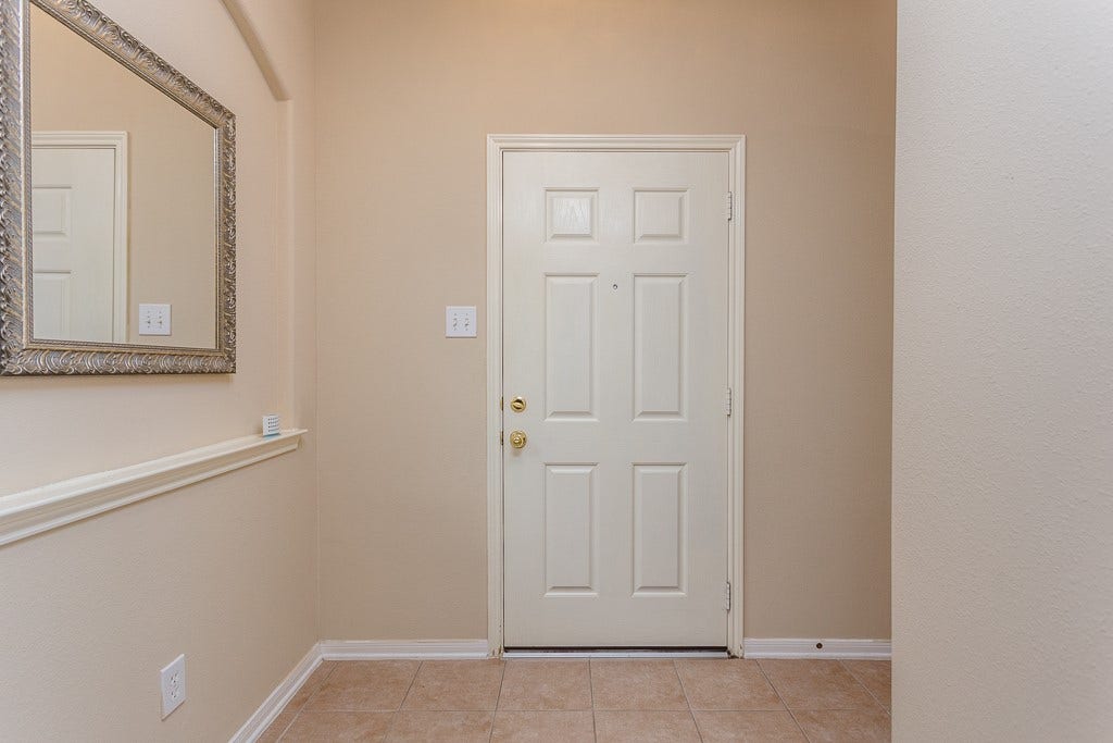 4530 Hall Croft Chase Lane, Katy, TX 77449 Inviting entryway with a classic white door, neutral walls offering a warm welcome.
