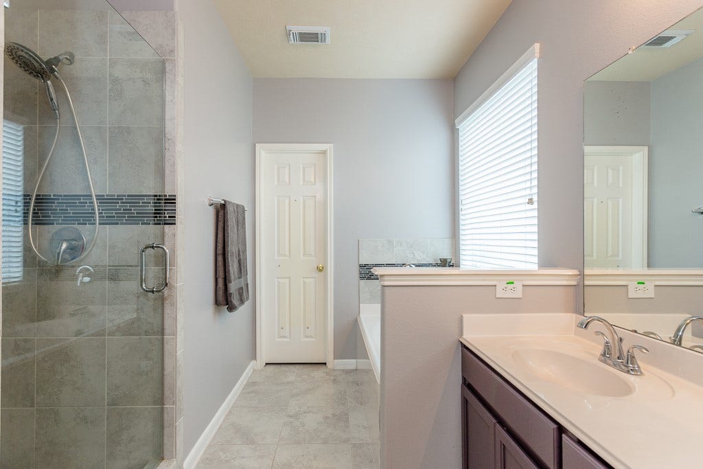 4530 Hall Croft Chase Lane, Katy, TX 77449 Modern bathroom featuring a sleek glass-enclosed shower, dual sinks with elegant fixtures, and a relaxing soaking tub.