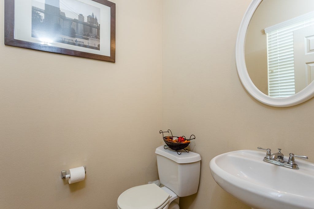 4530 Hall Croft Chase Lane, Katy, TX 77449 Charming half-bathroom featuring a sleek pedestal sink.