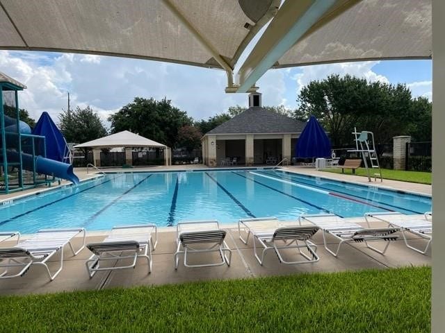 4530 Hall Croft Chase Lane, Katy, TX 77449 Enjoy relaxing and entertaining at this inviting community pool, complete with a waterslide, shaded seating, and a charming clubhouse.