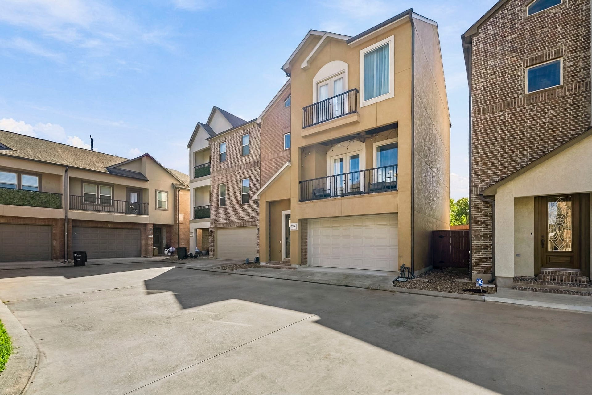 11009 Upland Forest Drive, Houston, TX 77043 Contemporary three-story townhouse with a two-car garage, featuring a charming balcony and a blend of modern and traditional architectural elements.