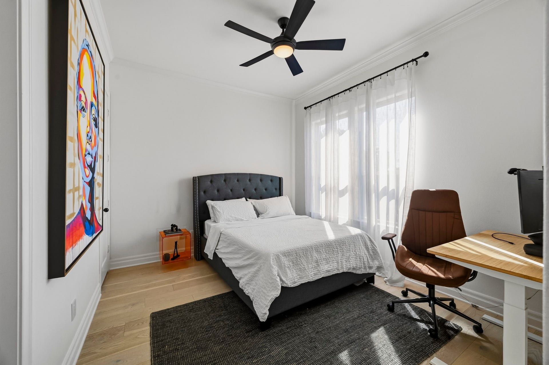 11009 Upland Forest Drive, Houston, TX 77043 Bright and modern bedroom featuring a large window and a functional workspace with a sleek desk and chair.