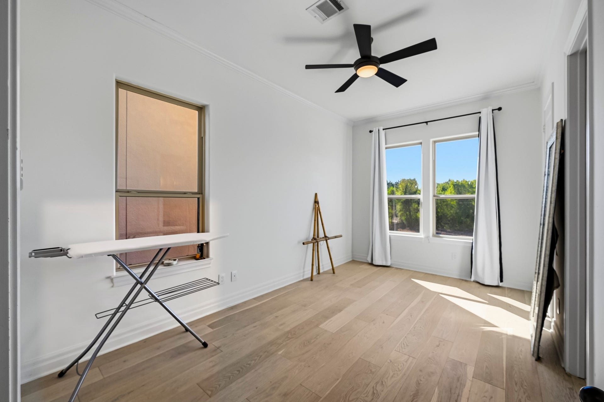 11009 Upland Forest Drive, Houston, TX 77043 Bright and airy room featuring large windows, sleek wood flooring, perfect for a creative workspace or cozy retreat.