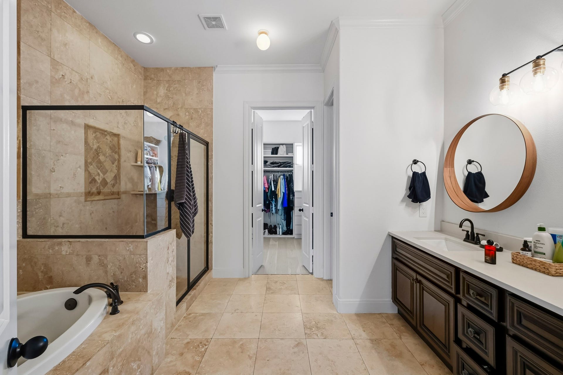 11009 Upland Forest Drive, Houston, TX 77043 Elegant bathroom featuring a spacious walk-in shower with glass enclosure, luxurious soaking tub, and dual vanity with stylish lighting, leading to a roomy walk-in closet.