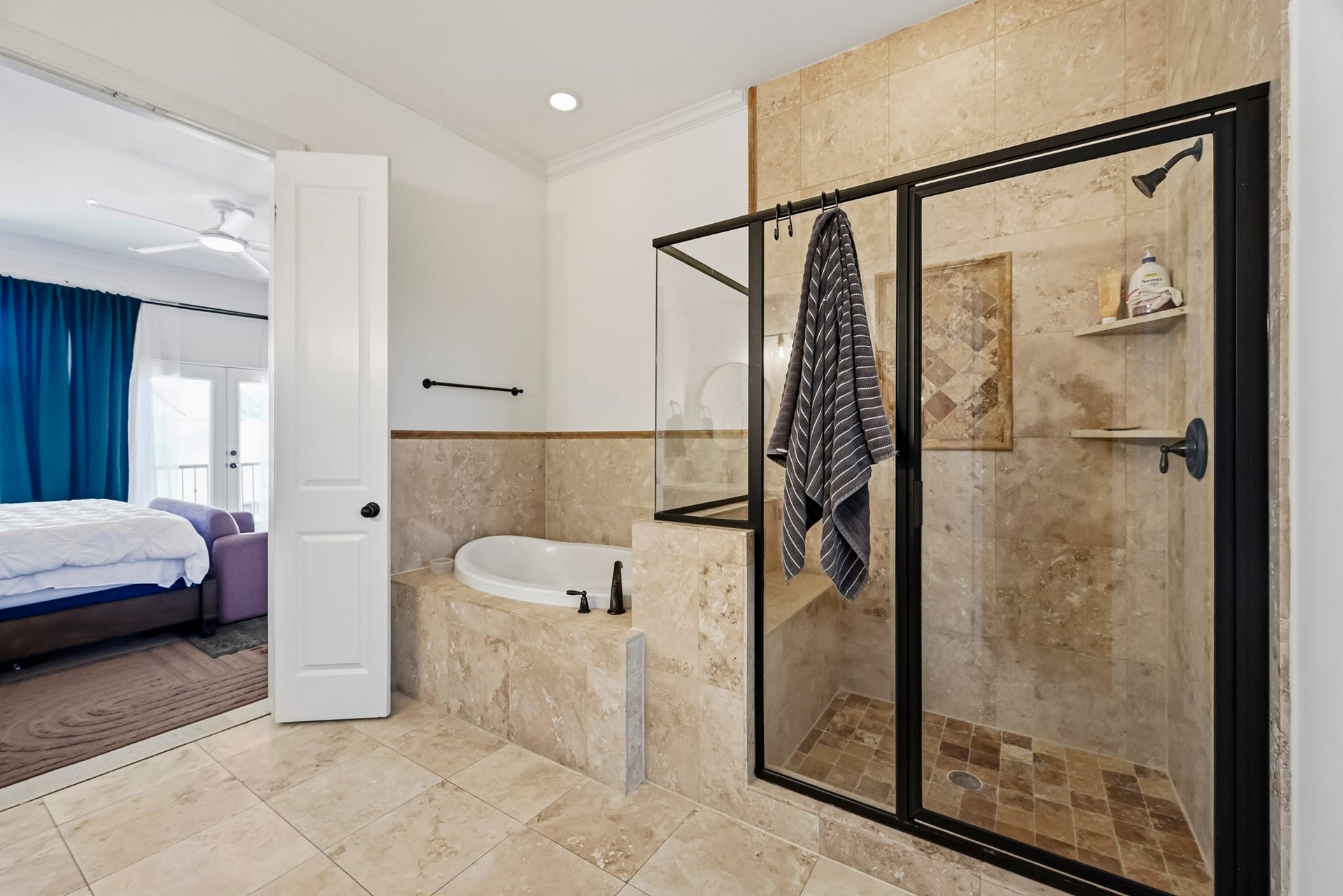 11009 Upland Forest Drive, Houston, TX 77043 Elegant bathroom featuring a spacious glass-enclosed shower and luxurious soaking tub, with direct access to a cozy bedroom.