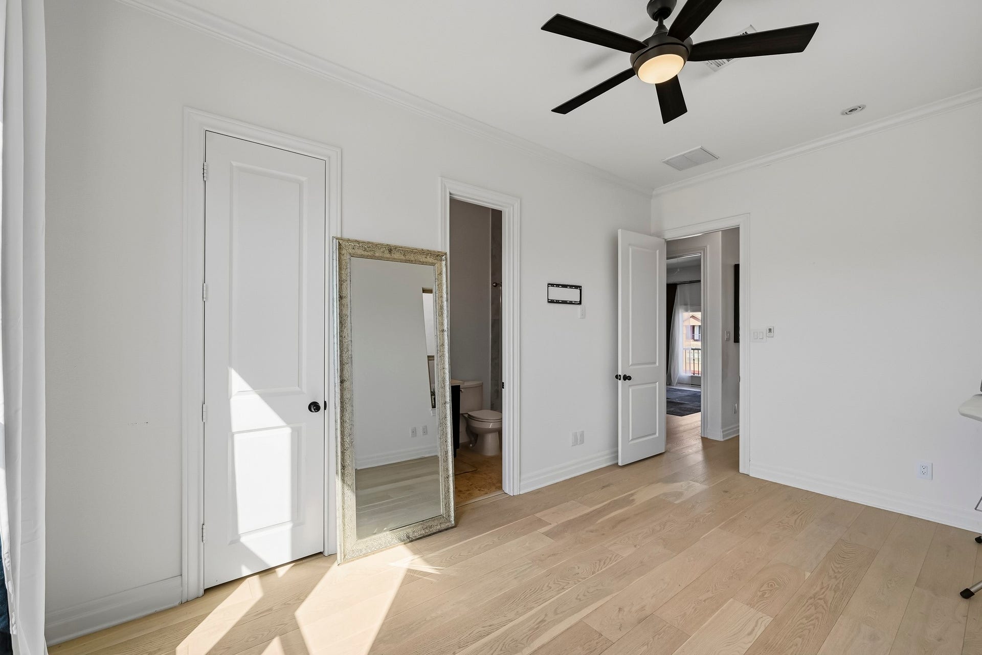 11009 Upland Forest Drive, Houston, TX 77043 Bright and airy room featuring light hardwood floors and ample natural light, with convenient access to an attached bathroom.