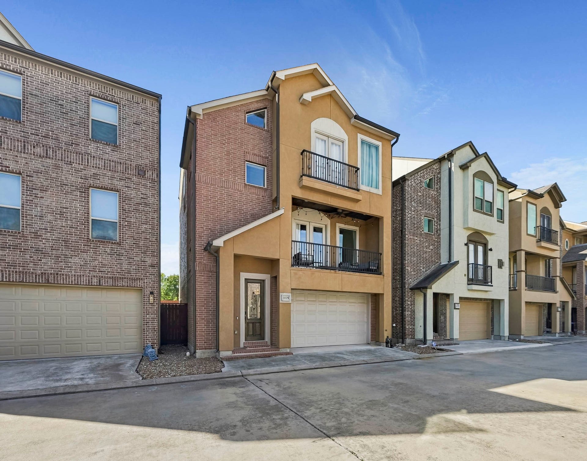 11009 Upland Forest Drive, Houston, TX 77043 Modern three-story townhouse with a charming balcony, two-car garage, and inviting entryway, nestled in a well-maintained community.