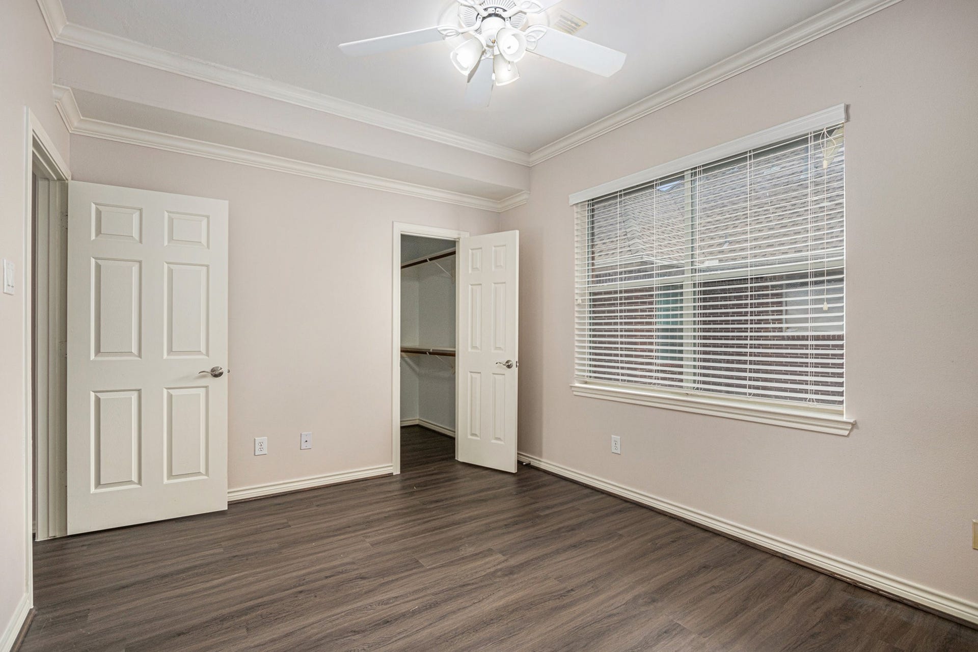 5001 Jackson Street, Houston, TX 77004 This room features sleek laminate flooring, neutral walls, and crown molding. It includes a ceiling fan, large window with blinds, and a walk-in closet.