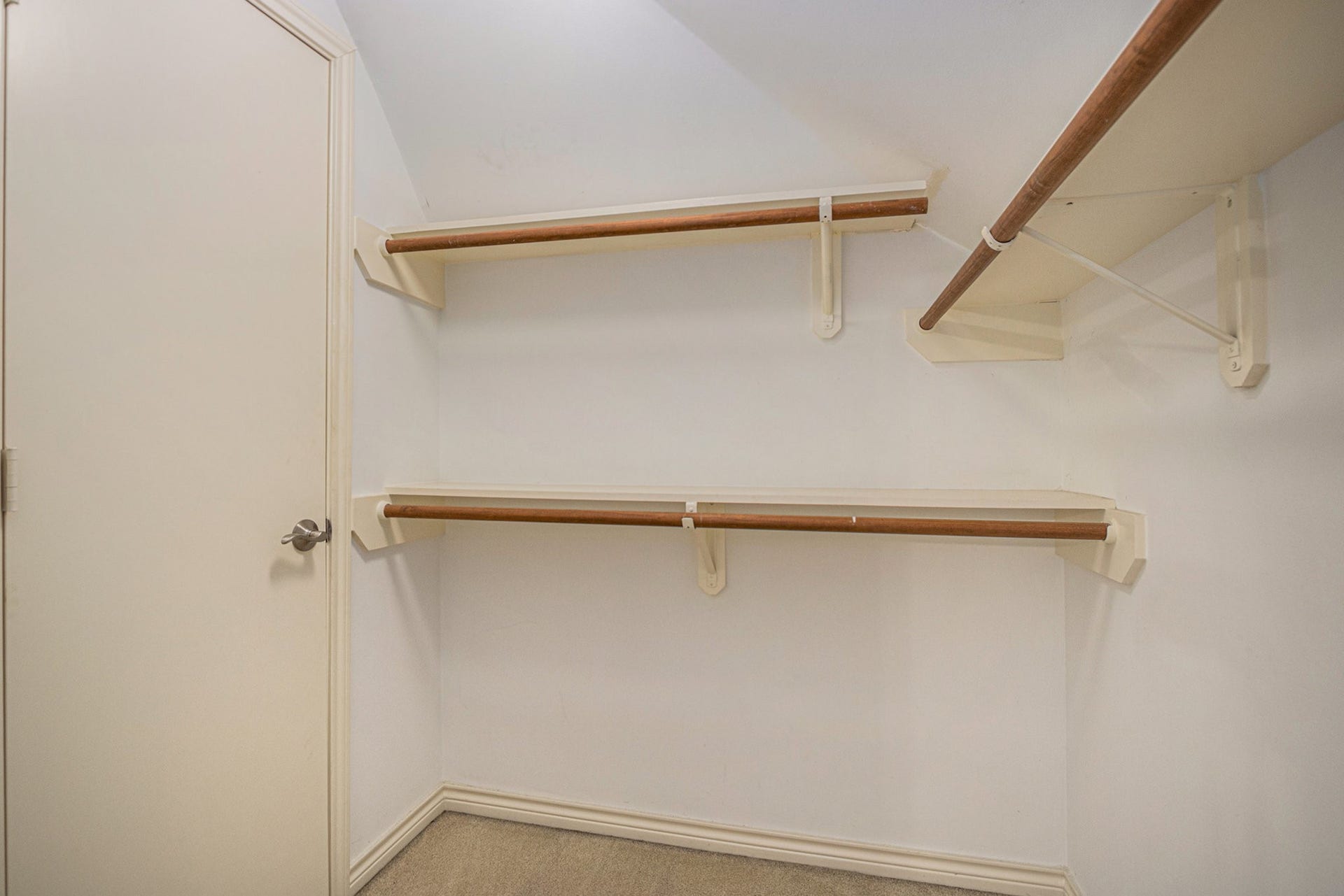 5001 Jackson Street, Houston, TX 77004 This photo shows a spacious walk-in closet with built-in shelves and hanging rods, offering ample storage space.
