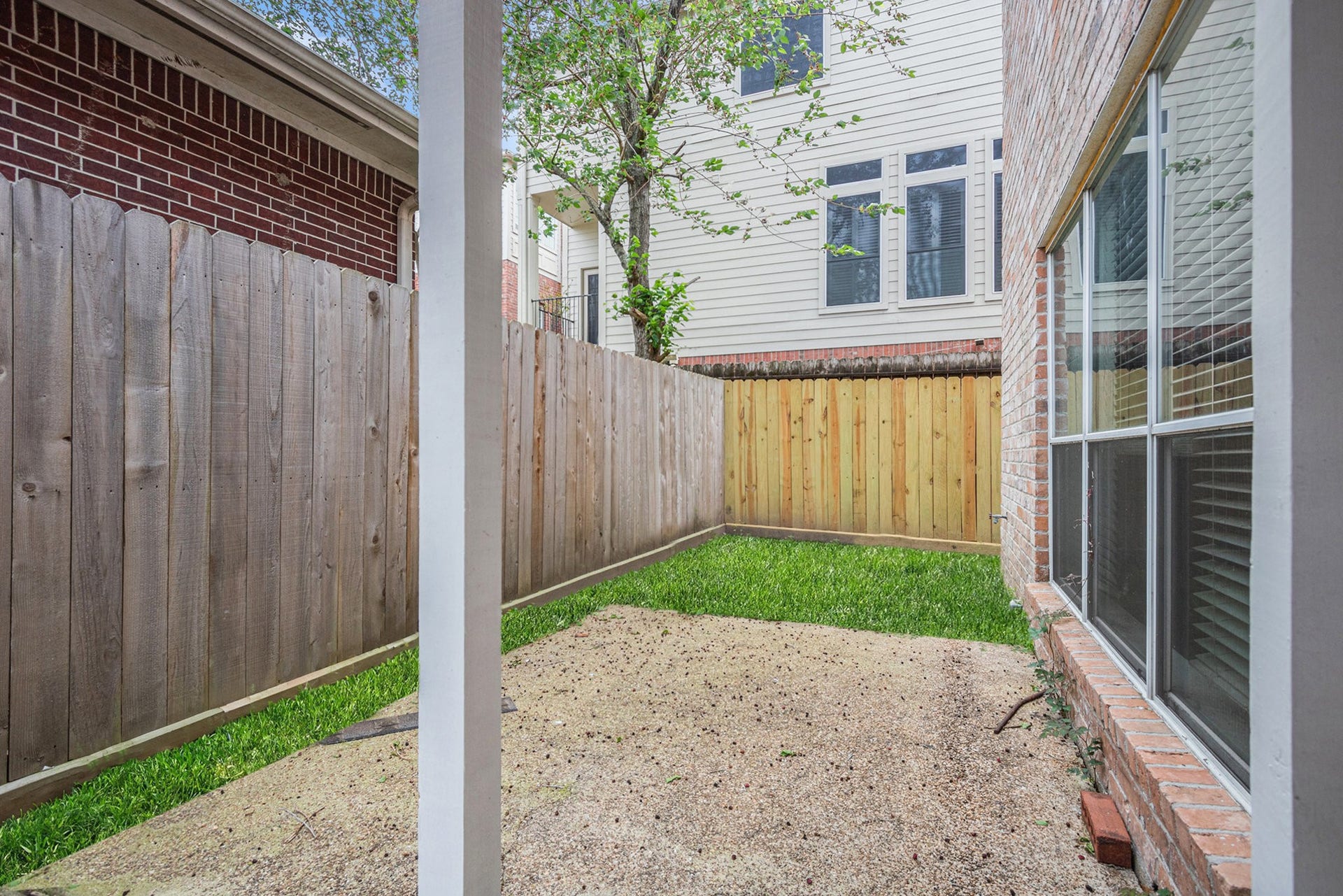 5001 Jackson Street, Houston, TX 77004 Cozy backyard space bordered by a wooden fence. Large windows provide natural light and a view of the yard. Perfect for a small garden or outdoor seating.