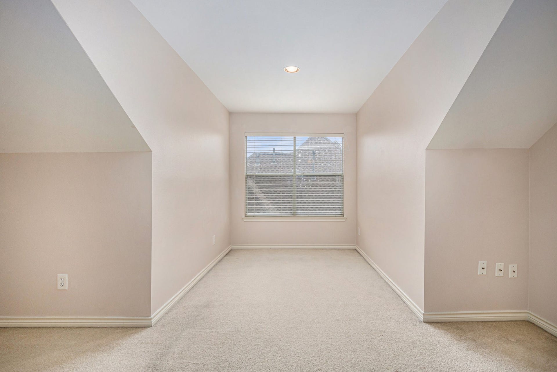 5001 Jackson Street, Houston, TX 77004 This is a cozy, carpeted attic space with sloped ceilings and a window providing natural light. Ideal for a small office or reading nook.