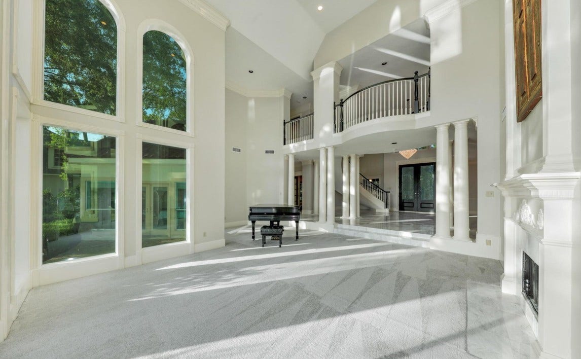 35 W Isle Place, The Woodlands, TX 77381 Spacious formal living room featuring marble flooring, high ceilings, and abundant natural light.