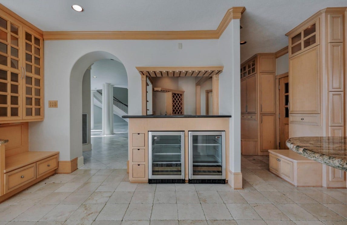 35 W Isle Place, The Woodlands, TX 77381 Elegant butler's pantry with custom cabinetry, wine storage, and beverage refrigerator.