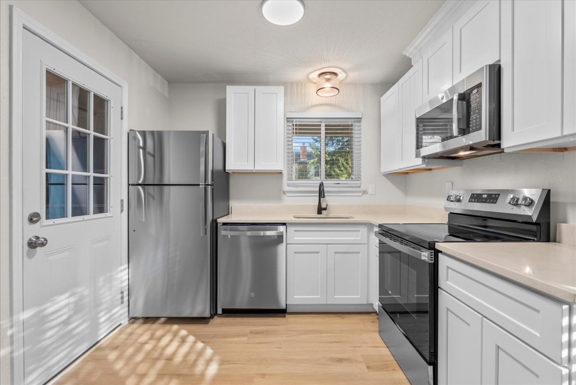 Extensively remodeled kitchen boasting sleek quartz countertops and soft-close cabinetry and drawers.