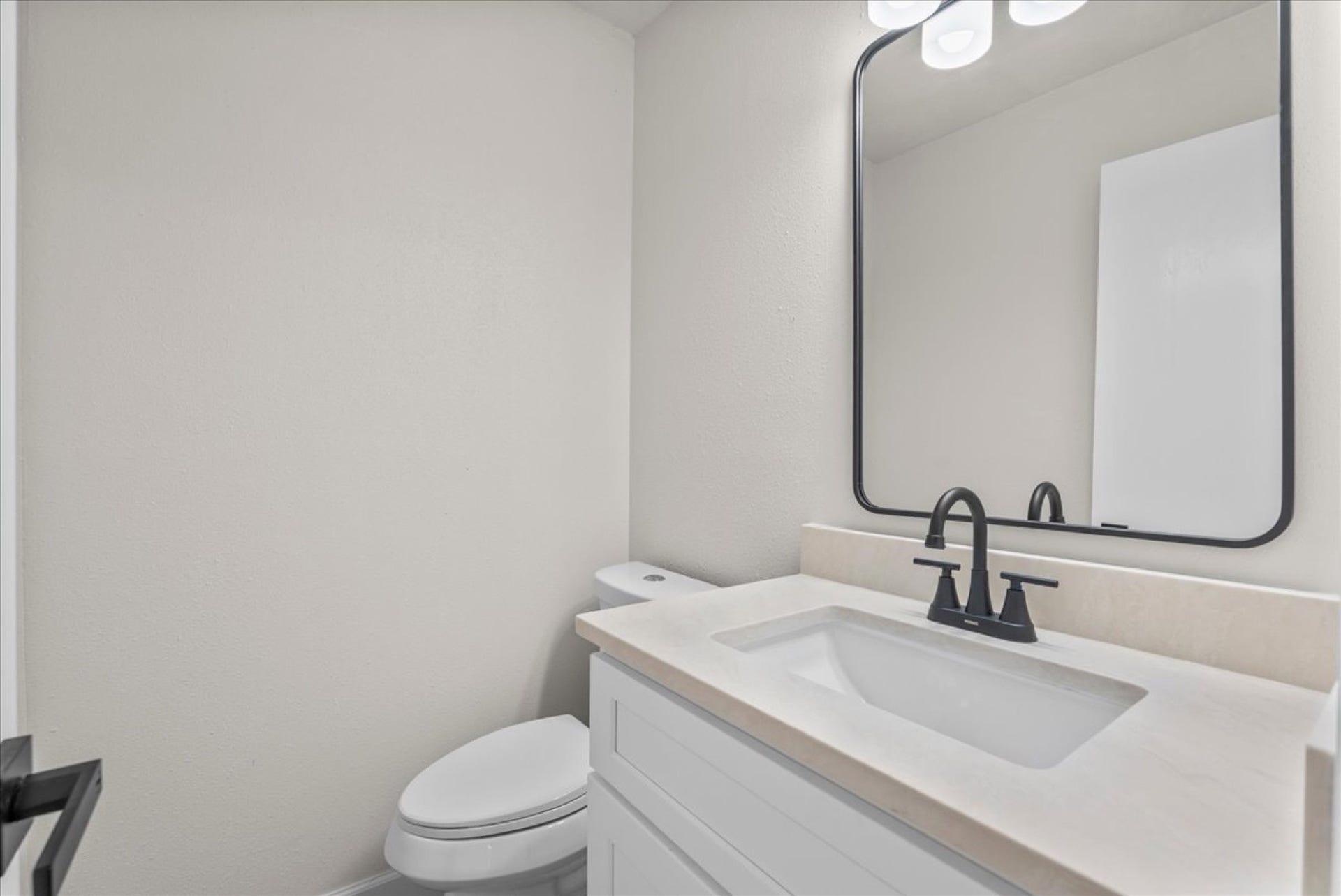Fully updated half bath equipped with a new quartz-topped vanity and modern plumbing fixtures.