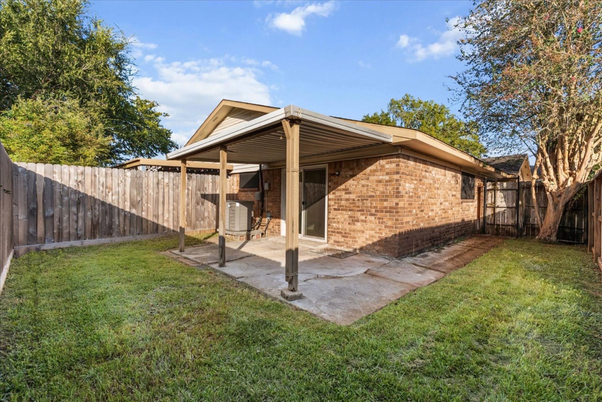 Private fenced back patio and yard area ideal for morning coffee, pets, and outdoor dining.