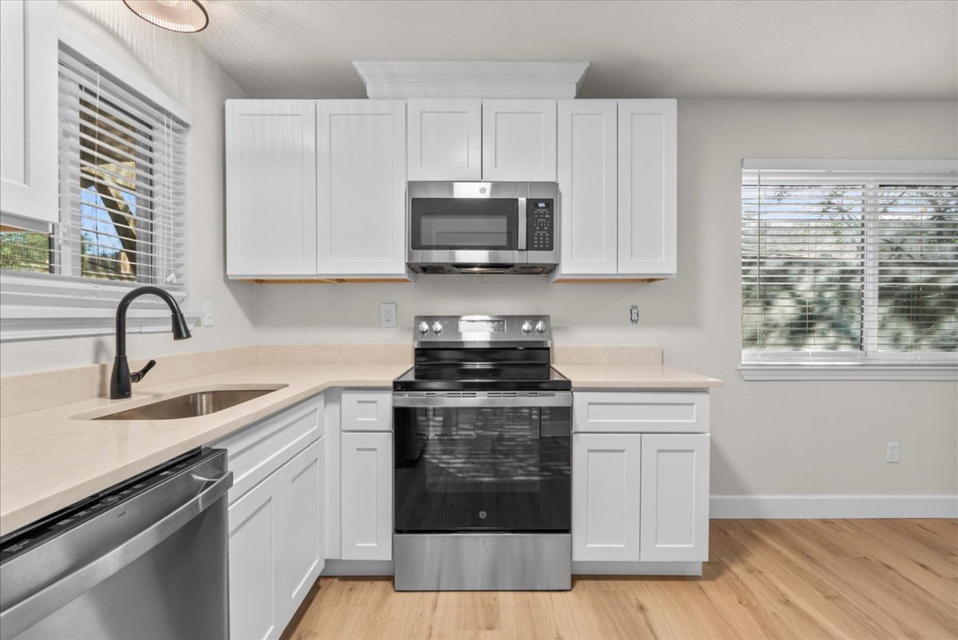 Fully equipped with a new suite of stainless steel GE appliances, including an electric range, microwave, dishwasher, and refrigerator.