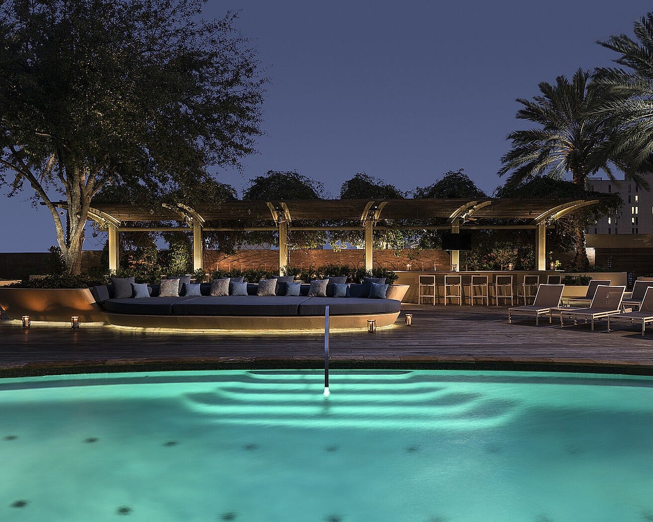 1111 Caroline Street, #2601, Houston, TX 77010 Pool deck offers an outdoor setting within the downtown property. Evening lighting outlines the water and surrounding terrace after sunset.