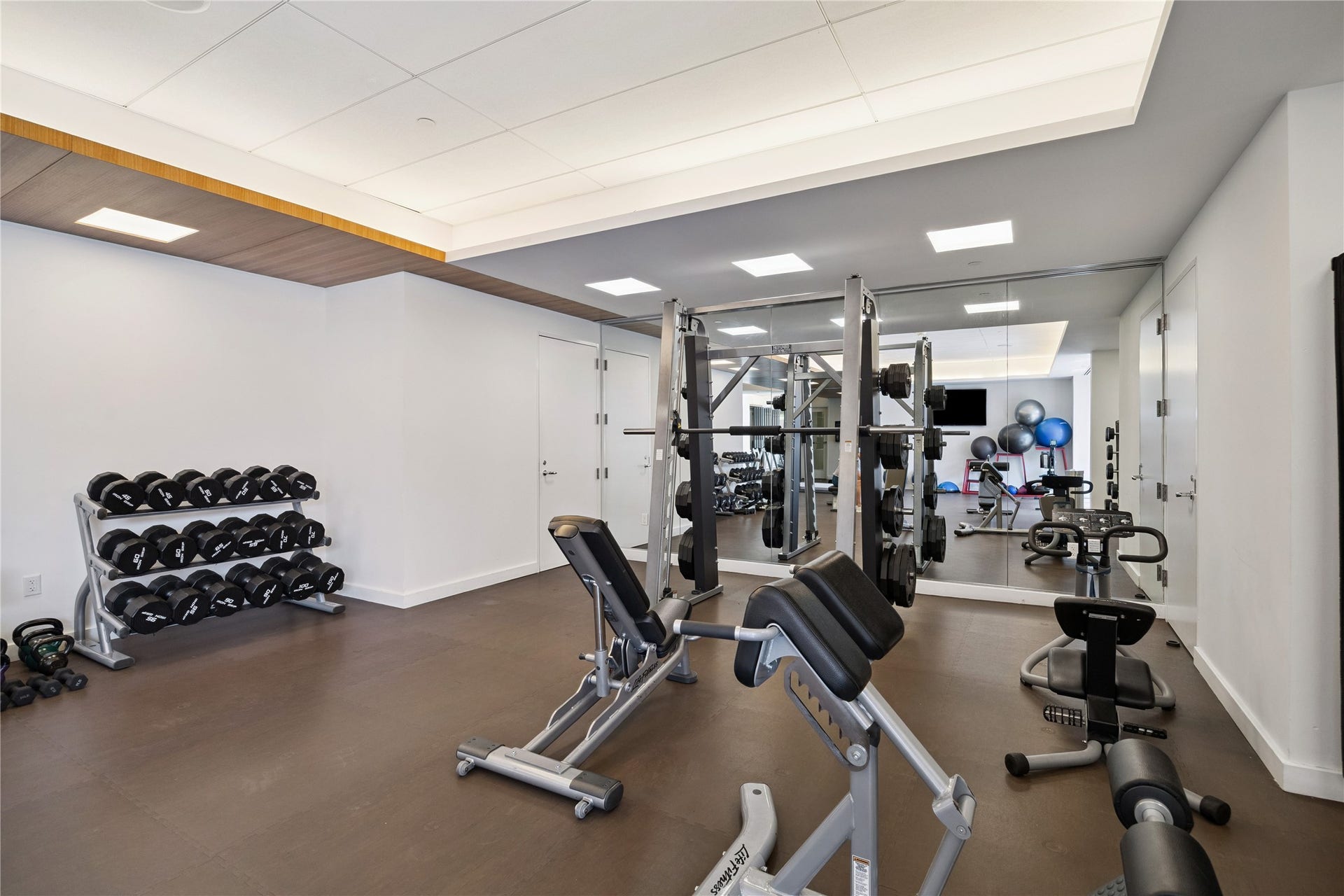 1111 Caroline Street, #2601, Houston, TX 77010 Dedicated strength area groups free weights and resistance equipment in one workout zone. Mirrored walls support movement checks during exercise.