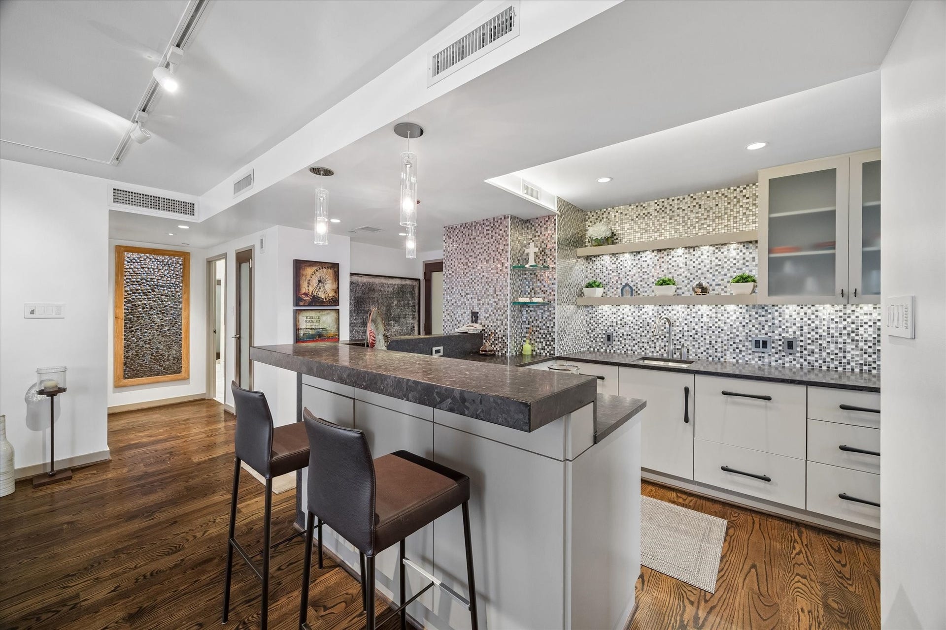 1111 Caroline Street, #2601, Houston, TX 77010 Glass front upper cabinets and open shelving combine enclosed storage with easy access to frequently used items. Counter space wraps around the kitchen, keeping preparation areas connected to the breakfast bar.