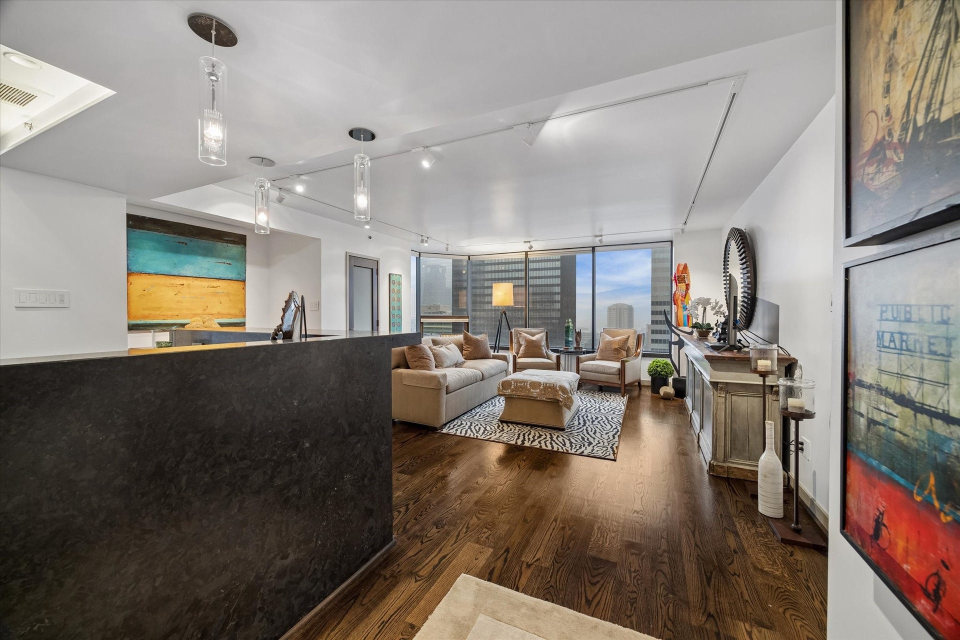 1111 Caroline Street, #2601, Houston, TX 77010 Open sightlines link the kitchen and living area, allowing conversation to continue across both spaces. Pendant lighting marks the breakfast bar while city views draw the eye toward the windows.