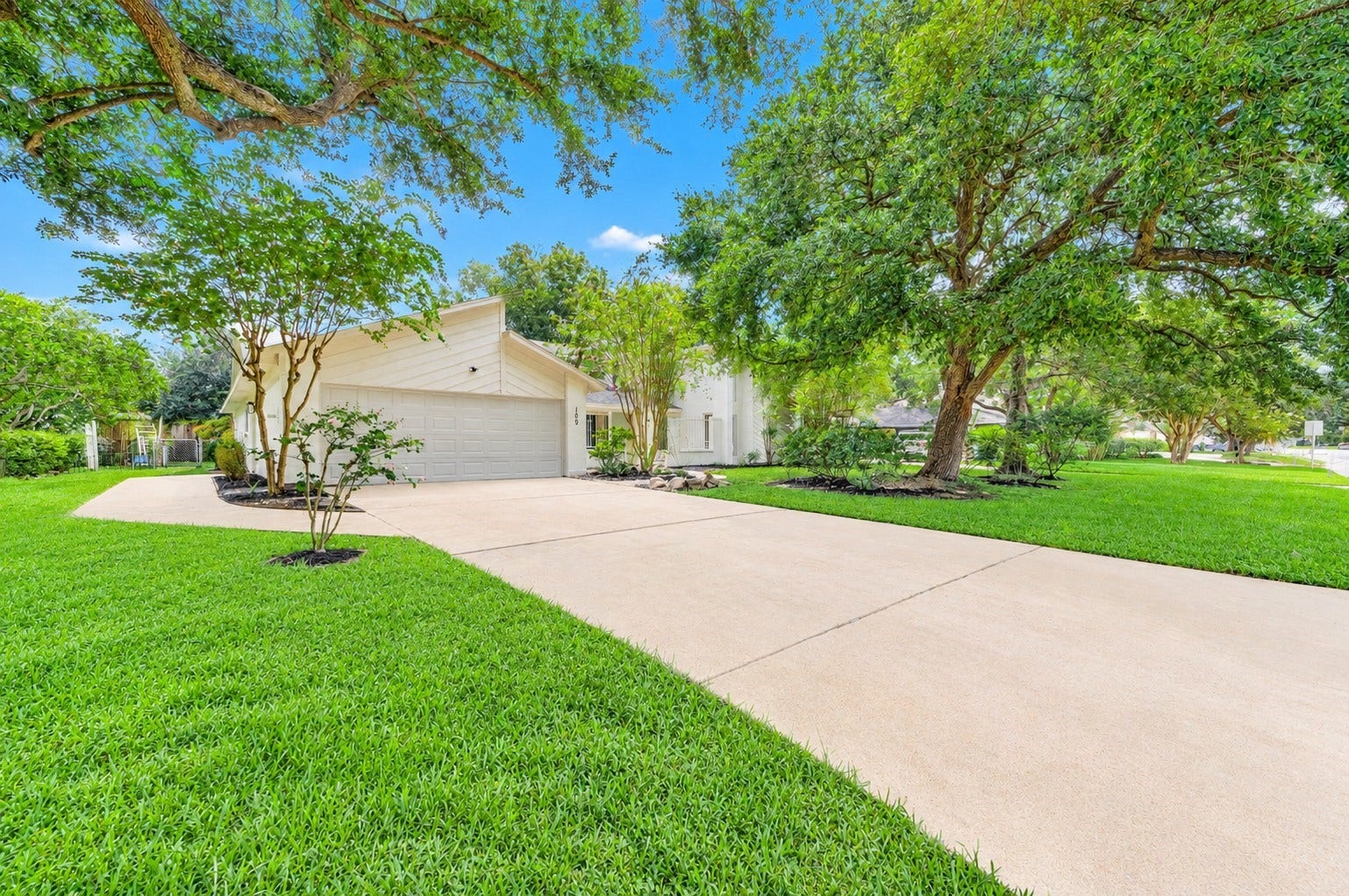 109 Dorado Drive, Friendswood, TX 77546 Welcoming curb appeal with expansive driveway and mature shade trees.