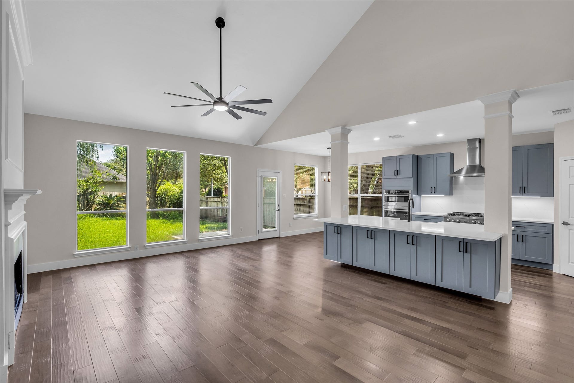22002 Madera Canyon Court, Richmond, TX 77469 Experience elegance in this open-concept living room and kitchen, featuring expansive windows, sleek cabinetry and a chic ceiling fan