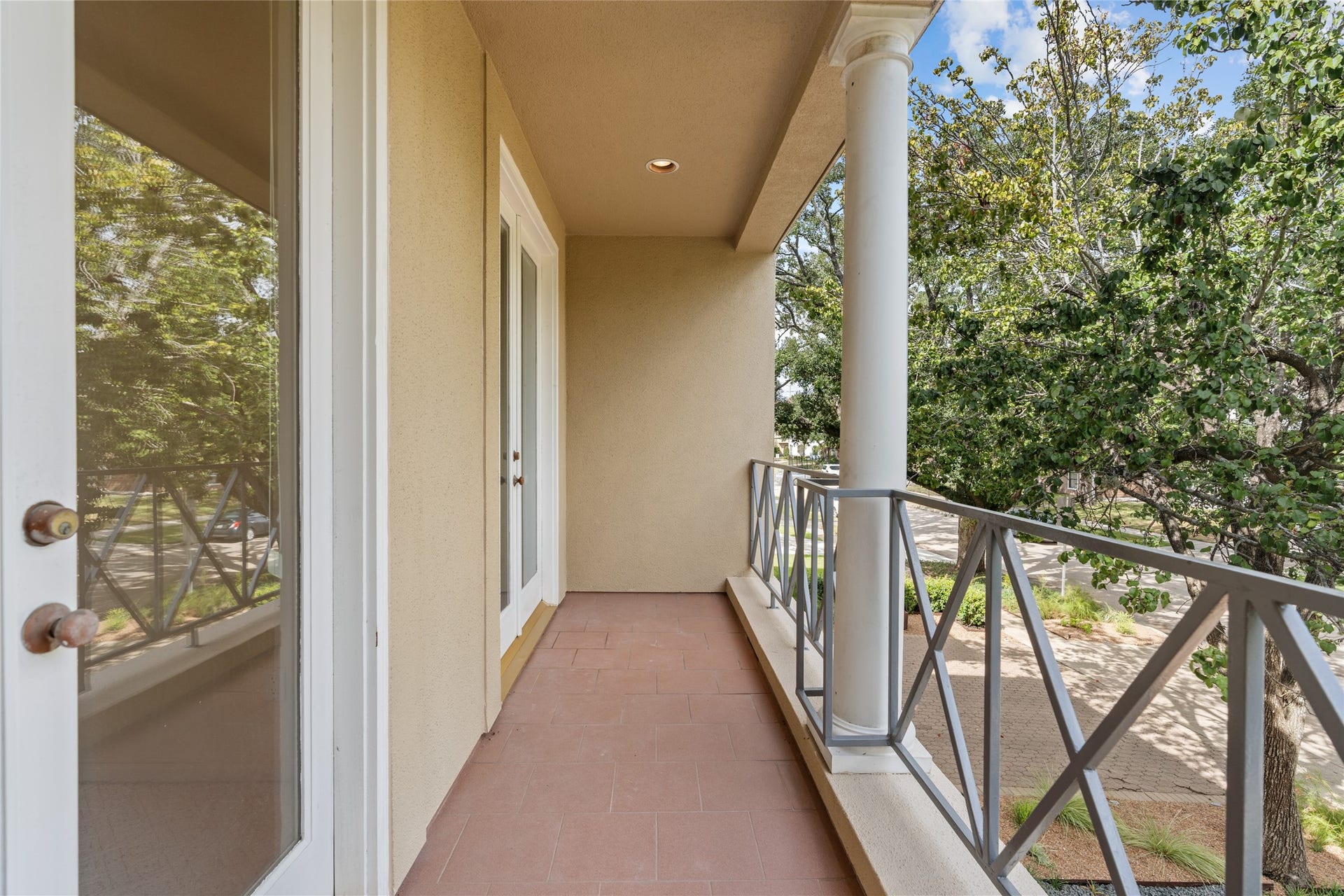 3923 Childress Street, #A, Houston, TX 77005 Charming front balcony off bedroom with elegant railings and a cozy outdoor space overlooking lush greenery, perfect for relaxation or entertaining.