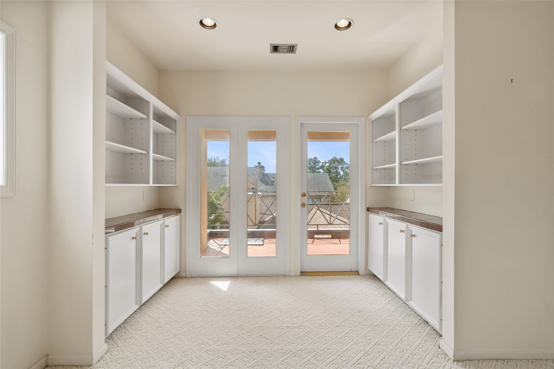 3923 Childress Street, #A, Houston, TX 77005 Bright and airy sitting area in the primary bedroom featuring built-in shelving and cabinetry, leading to a balcony. Ideal for a cozy nook or home office.
