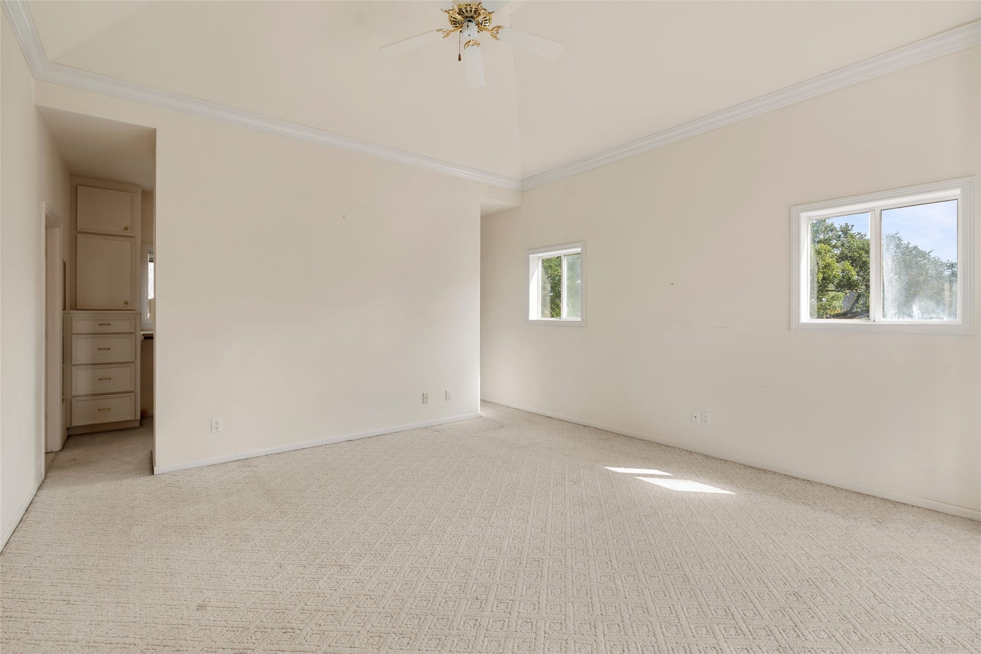 3923 Childress Street, #A, Houston, TX 77005 Very spacious primary room with neutral tones, featuring a vaulted ceiling and natural light from two windows, offering a serene and airy atmosphere.