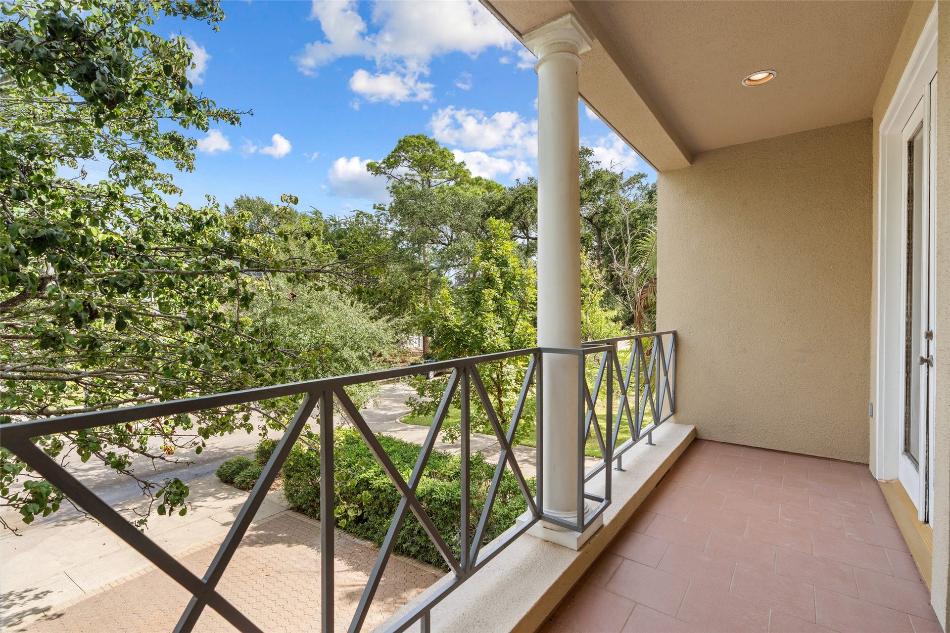 3923 Childress Street, #A, Houston, TX 77005 Charming front balcony off bedroom with elegant railings and a serene view of lush greenery, perfect for relaxing outdoors.