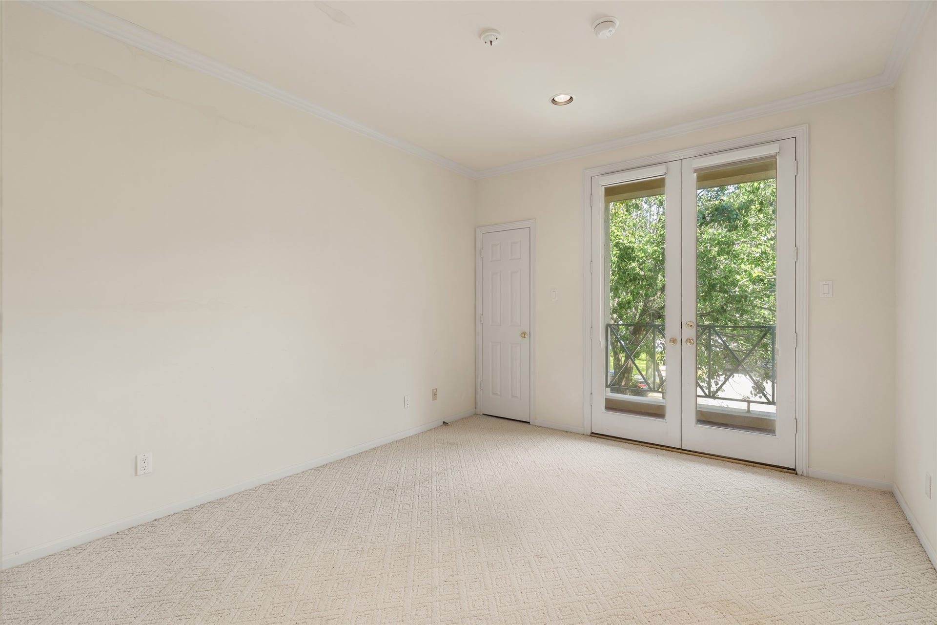 3923 Childress Street, #A, Houston, TX 77005 Bright and airy room featuring French doors that open to scenic views, complemented by soft carpeting and neutral walls.