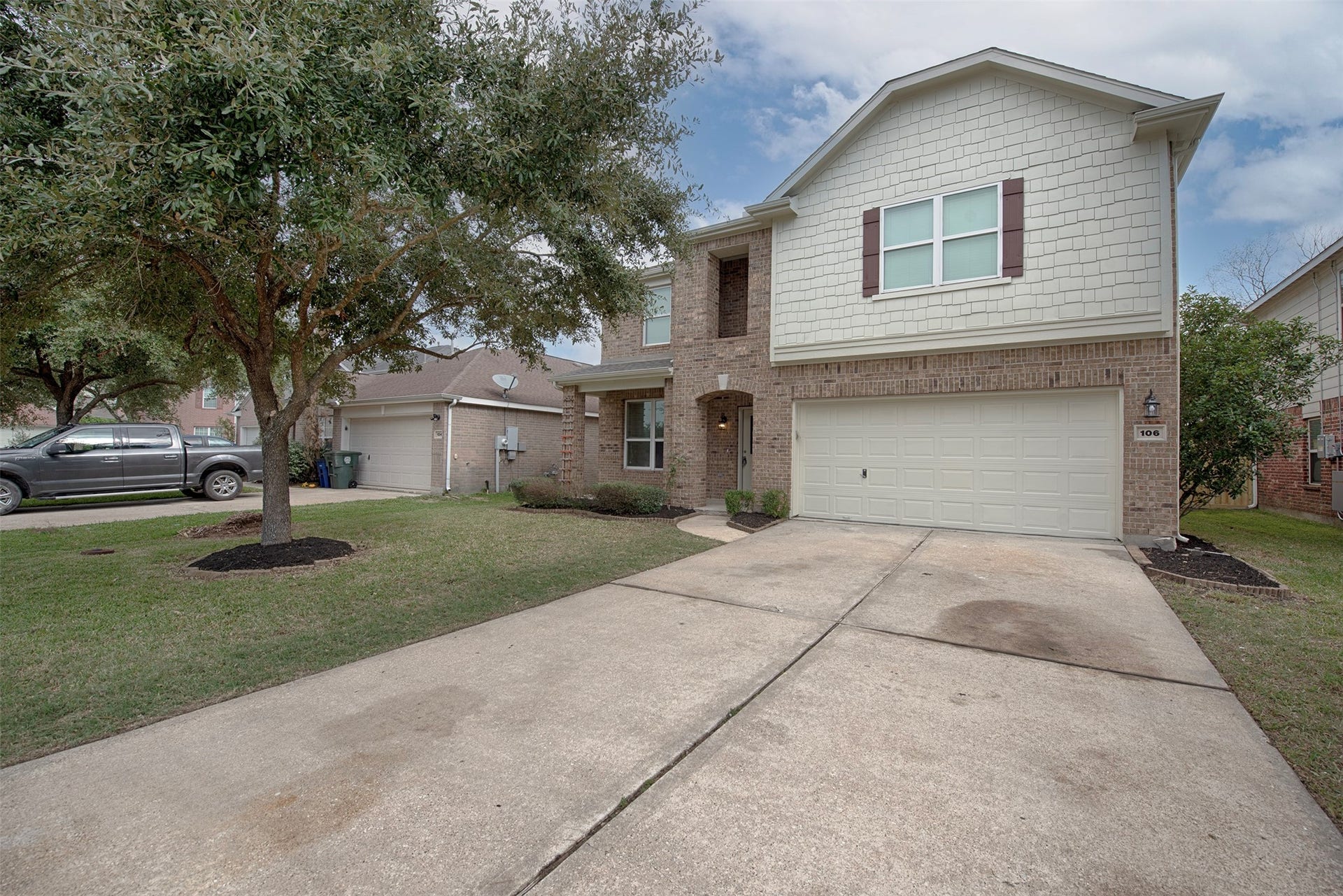 106 Easton Glen Lane, Dickinson, TX 77539 A view of the home which features a gorgeous oak tree and spacious front yard. Home is minutes from I 45 for commuters.