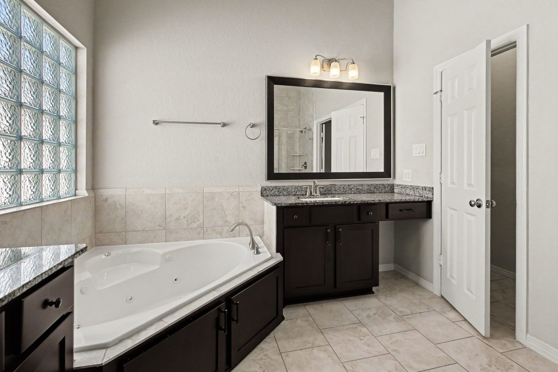 1506 Peyton Oaks Place, Houston, TX 77043 Primary bathroom with double vanities, bathtub and walk-in shower