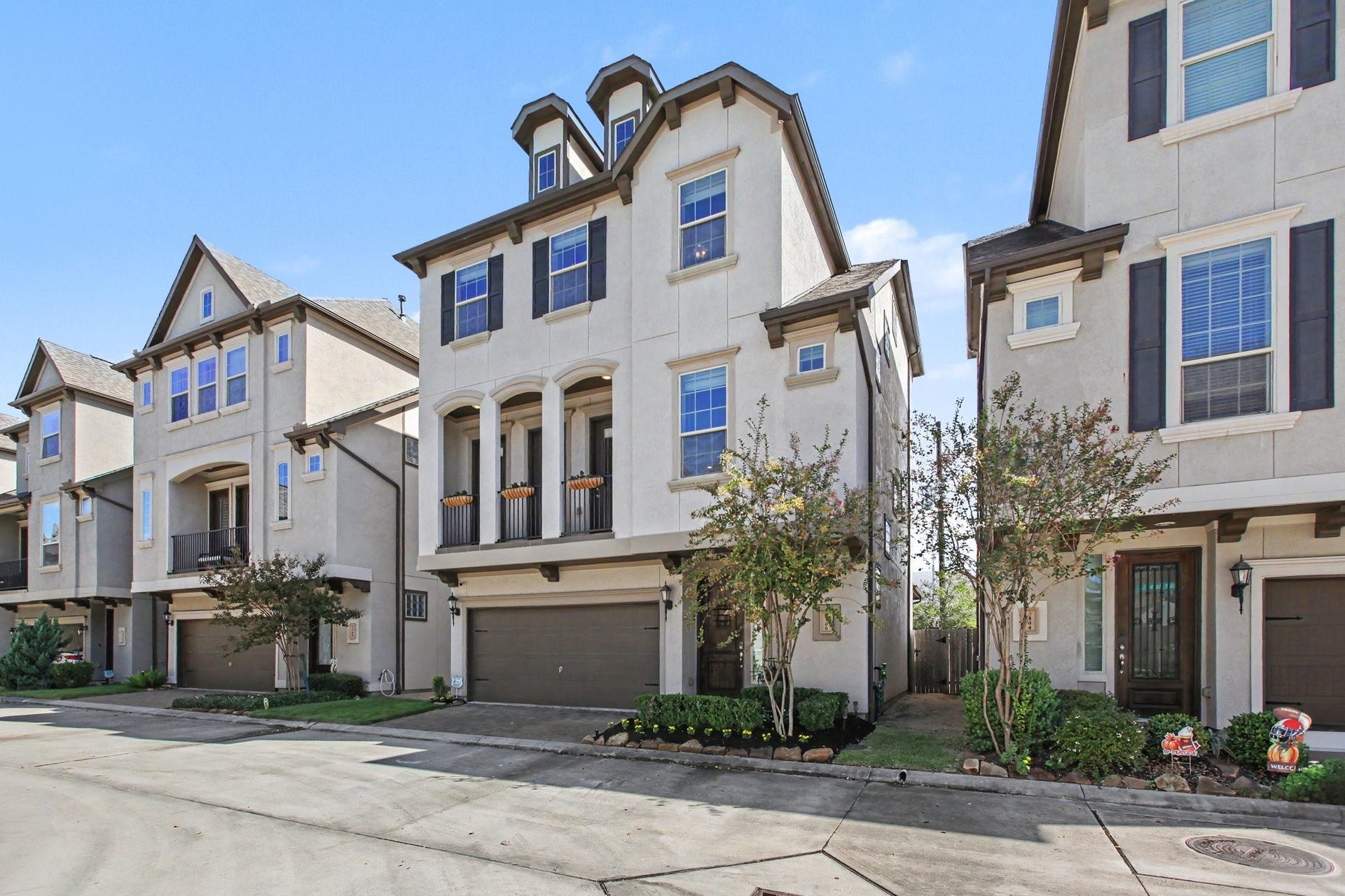 1506 Peyton Oaks Place, Houston, TX 77043 Elegant three-story home featuring a charming covered balcony, attractive architectural details