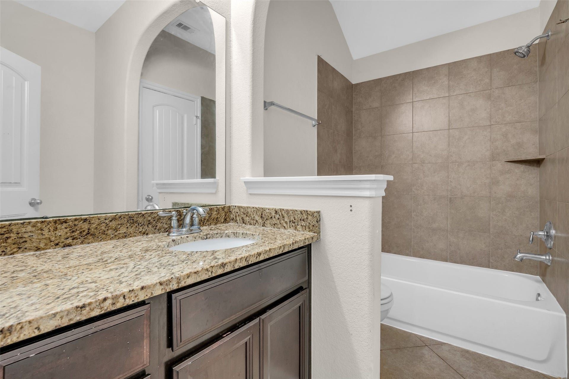7 Ember Branch Drive, Missouri City, TX 77459 A second upstairs bath with a granite vanity and tiled tub/shower surround.